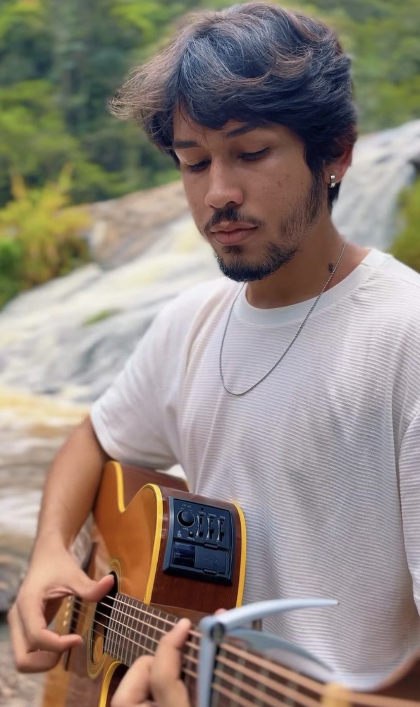 Criador da marca Notas de Café tocando violão